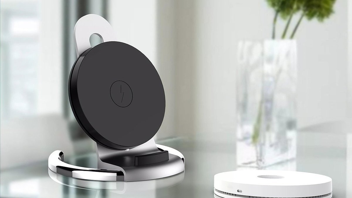 Beyaz renkli modern bir kablosuz şarj cihazı, üzerinde yatan akıllı telefonla birlikte minimalist kompozisyon