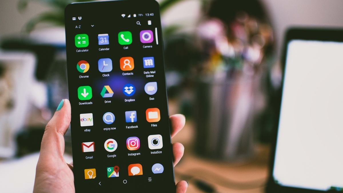 Genç kadının elinde modern bir akıllı telefon, sistem bildirimine bakıyor, doğal gün ışığı